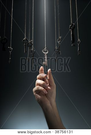 Mano scegliendo una chiave appeso tra altri.