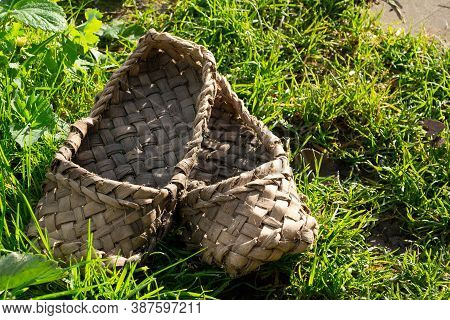 Old Bast Shoes On The Green Grass,ancient Shoes.