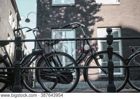 Bicycles Parked On A Canal Fence In Amsterdam, Netherlands.