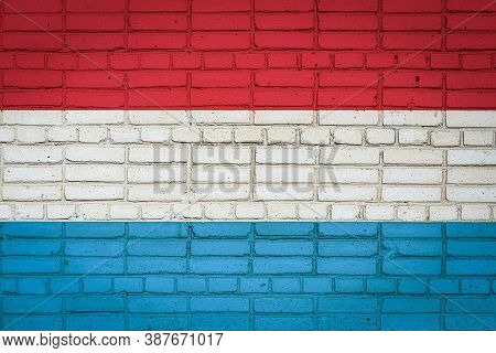 National Flag Of Luxembourg Depicting In Paint Colors On An Old Brick Wall. Flag  Banner On Brick Wa