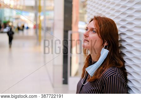 A Young Woman With A Medical Mask Removed In A Shopping Center, Copy Space For Text