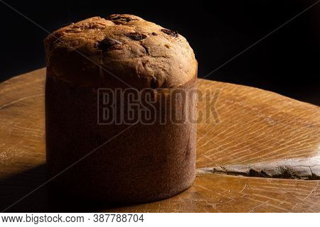 Panettone With Chocolate Chips On Rustic Wood With Black Background, Selective Focus.