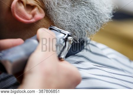 Trimting A Beard In A Barbers Salon To A Man