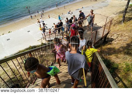 La Teste-de-buch - 08/25/2020: People With Protection Mask Descending A Wooden Walkaway To The Sea