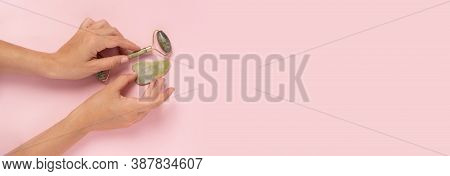 Guasha Green Natural Gemstone Face Roller On Pink Background. Anti Aging Self Care Tool.