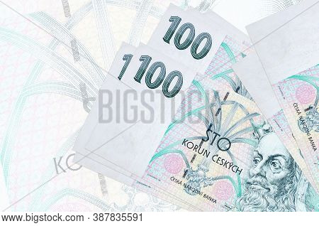 100 Czech Korun Bills Lies In Stack On Background Of Big Semi-transparent Banknote. Abstract Present