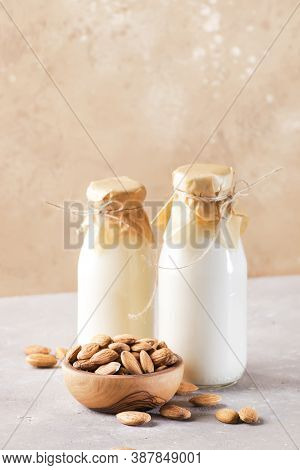 Vegan Almod Milk And Cream In Bottles, Closeup, Brown Background. Non Dairy Alternative Milk. Health