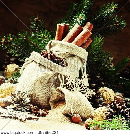 Christmas Atmosphere: Spices, Candies, Cones And Nuts With Fir Paws On A Vintage Wooden Background, 