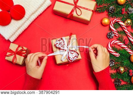 Christmas Gifts, Children's Hands Open A New Year's Gift On A Red Background, Christmas Composition 