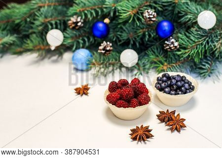 Christmas Layout. Berries On The Table, Blue Decorations On The Fir Branches. New Year