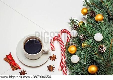 Christmas Layout With A Cup Of Coffee On The Table, Decorations, Fir Branches, Candy And Cinnamon. N