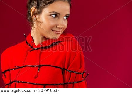 Portrait Of Young Beautiful Woman Covered With Garland Standing Over Isolated Red Background Smiling