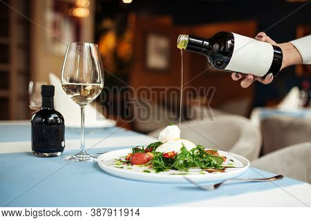 Pouring Oil On Spanish Buratta Salad On The Restaurant Table