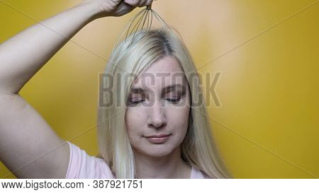 A Caucasian Blond Woman Enjoy Head Scalp Massage By Anti Stress Acupuncture Metal Octopus Tool, Equi