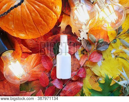 Mockup Of White Plastic Spray Bottle Pumpkin, Magic Lights And Bright Autumn Leaves. Atmospheric Fal