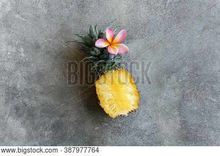 Pineapple And Frangipania On A Stone Table. Tropical Fruits. Top View. Free Space For Your Text.