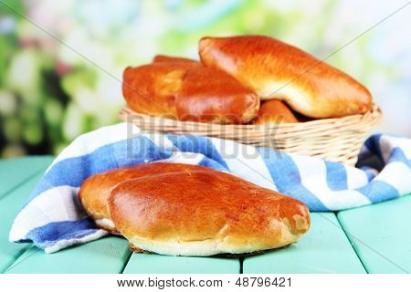 Empanadillas al horno frescos en cesta de mimbre, sobre fondo brillante