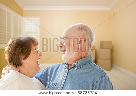 Happy Senior Couple In Room with Moving Boxes on the Floor.