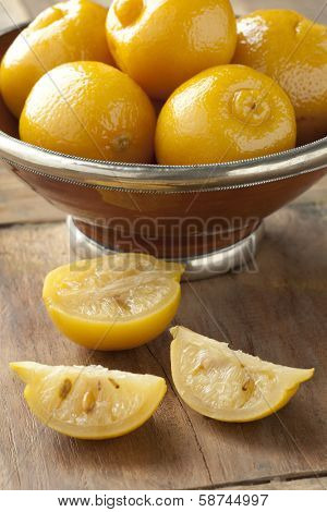 Whole and half preserved Moroccan lemons in a bowl