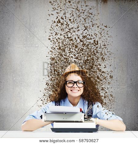 Young funny woman in glasses using typewriter