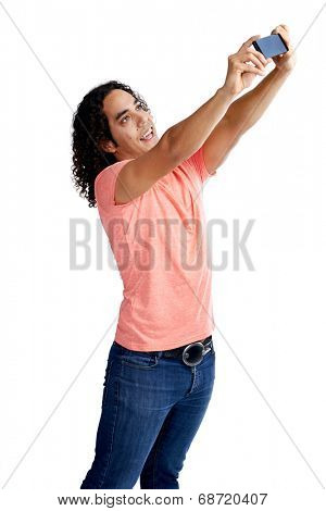 Mixed race man in casual clothing taking a selfie with his cameraphone in studio
