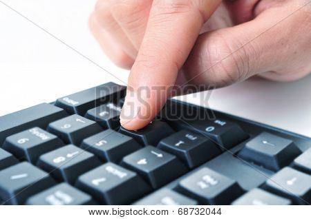 closeup of the hand of a man using the numeric keypad of a computer keyboard