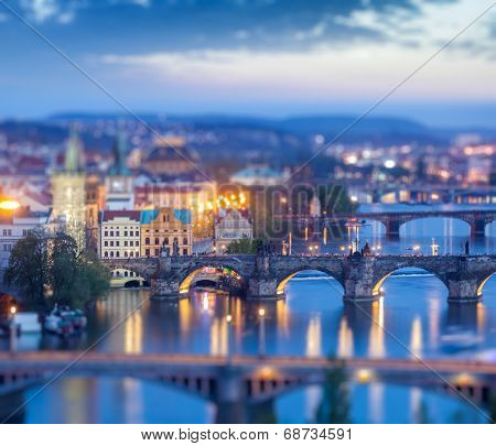Travel Prague concept background - elevated view of bridges over Vltava river from Letna Park with tilt shift toy effect shallow depth of field. Prague, Czech Republic in twilight