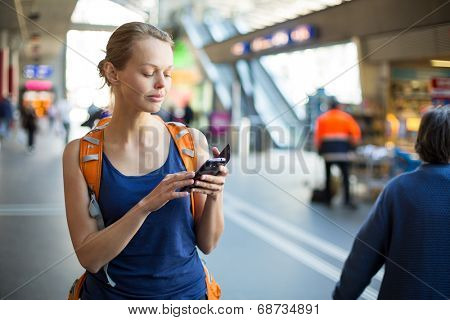 Pretty, young woman in a trainstation, waiting for her train, boarding a train (color toned image)