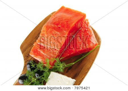 Rose saumon sur une plaque en bois avec du fromage