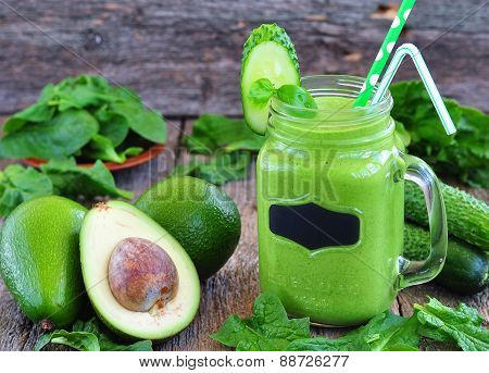 Green vegetable smoothie on wood background