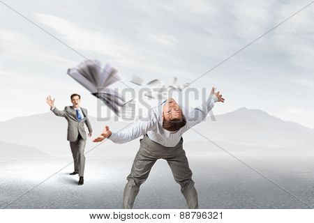 Young businessman trying to evade from thrown book