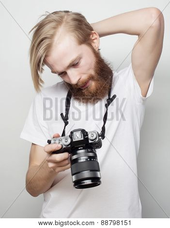 Travel, technology and life style concept: young bearded  photographer taking pictures with digital camera.