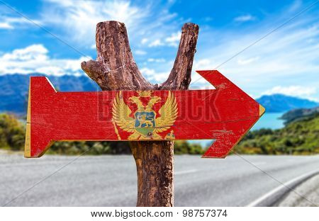 Montenegro Flag wooden sign with road background