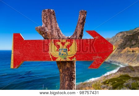 Montenegro Flag wooden sign with coast background