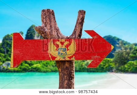 Montenegro Flag wooden sign with beach background
