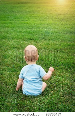 Little baby sitting on the grass