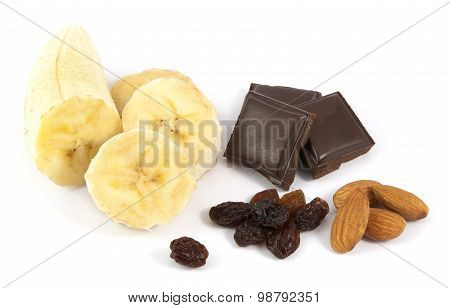 Peeled sliced banana with chocolate, almonds and raisins on white background
