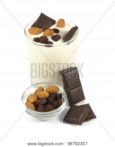 Sweet yogurt desert with chocolate, almonds and raisins on white background