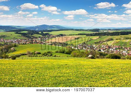 panoramic view of Horni Lidec village with meadow ful of dandelions and beautiful clouds - Carpathiam mountains - Czech Republic