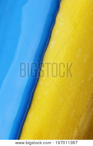 Pouring blue paint over yellow background, macro closeup.Texture.Abstract