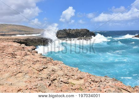 Rock cliffs with water from waves running down them near Andicuri beach.