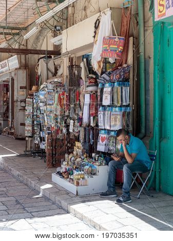 Jerusalem Israel July 14 2017 : The seller is sitting near the souvenir shop in the Muristan Street in the old city of Jerusalem Israel.
