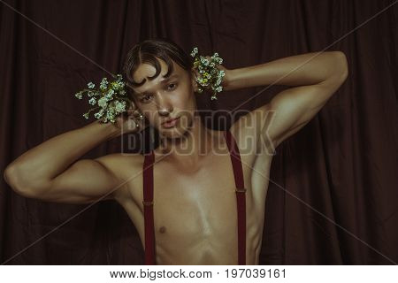 Guy with a naked torso and flowers near the head