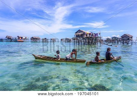 Semporna,Sabah,Malaysia-Apr 23,2017:Sea Gypsy kids on unique handmade boats with clear water on at Bodgaya island,Semporna,Sabah,Malaysia.