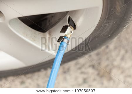 Filling air into a car tire at the self service station