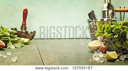 Mojito cocktail ingredients (fresh mint, lime, ice) on rustick background