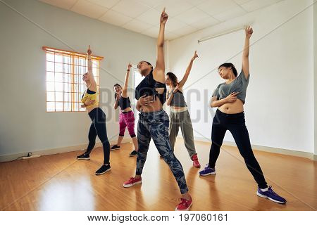 Attractive hip-hop dancers gathered together in modern dance hall in order to participate in final rehearsal