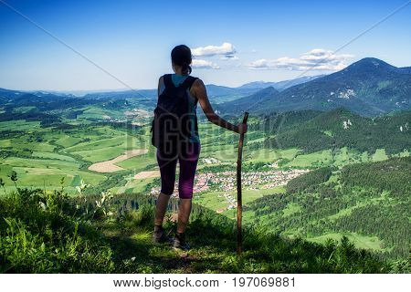 Hiking woman watching from top of the hill Hrdos (Ostre) and watching on beautiful summer landscape