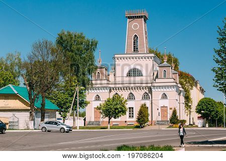 Chachersk, Belarus - May 14, 2017: Young Woman Walking On Street Near Old City Hall In Sunny Summer Day. Town Hall In Chechersk
