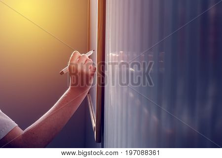 School teacher writing on classroom whiteboard during the lecture selective focus